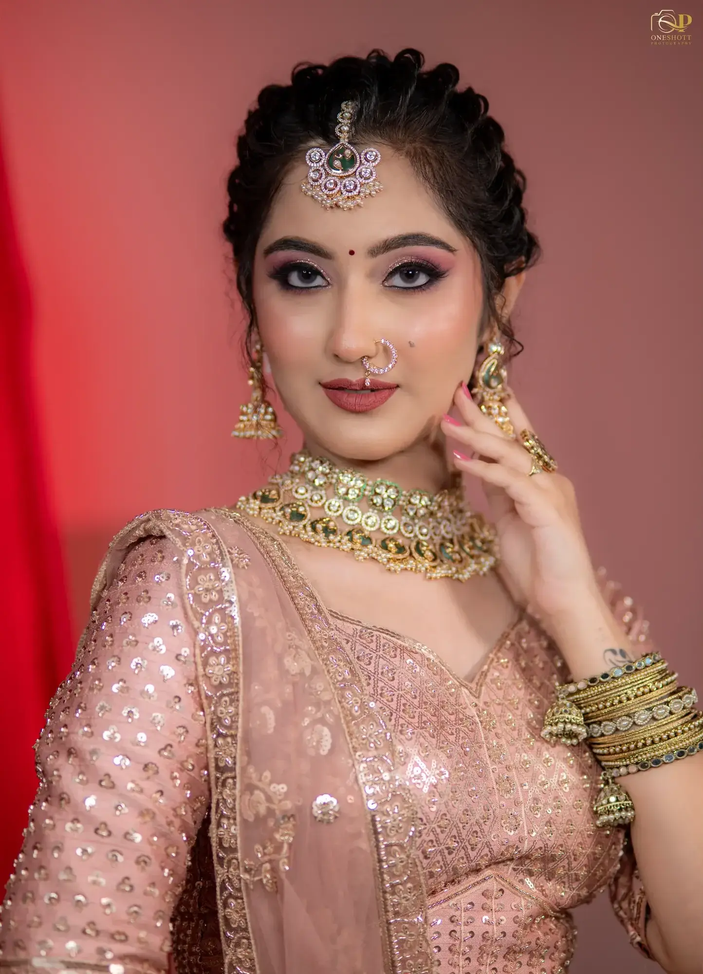 Bride in a blush pink lehenga with a crystal choker and bangles